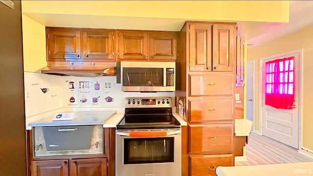 kitchen with stainless steel appliances and light hardwood / wood-style flooring