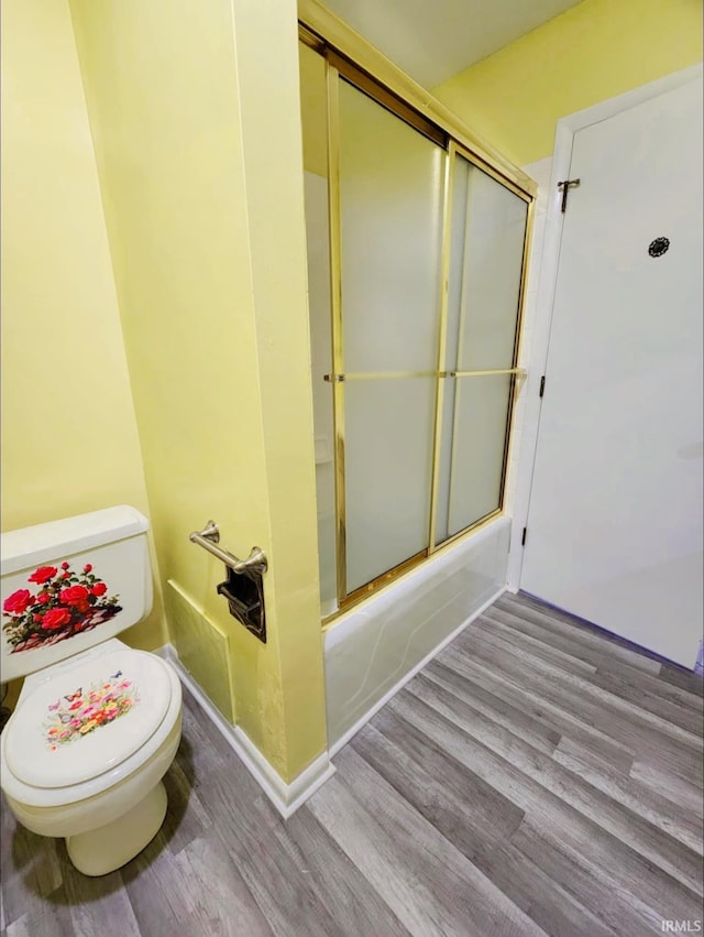 bathroom with shower / bath combination with glass door, wood-type flooring, and toilet