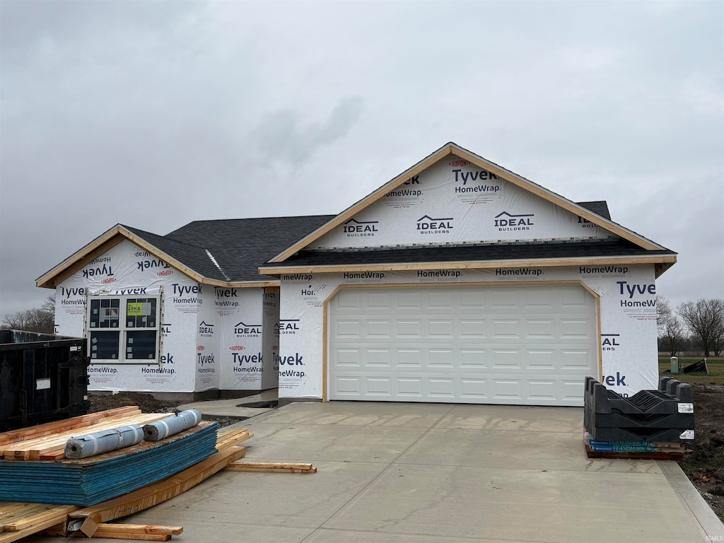 unfinished property with concrete driveway, an attached garage, and stucco siding