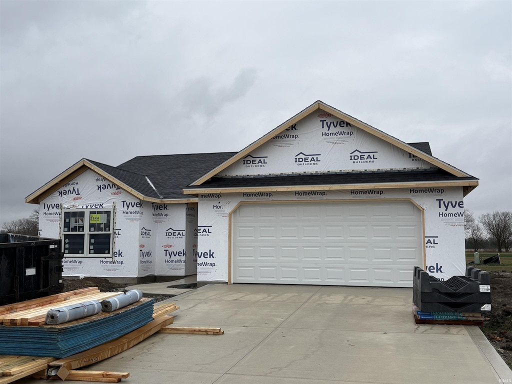 unfinished property with a garage, concrete driveway, and stucco siding