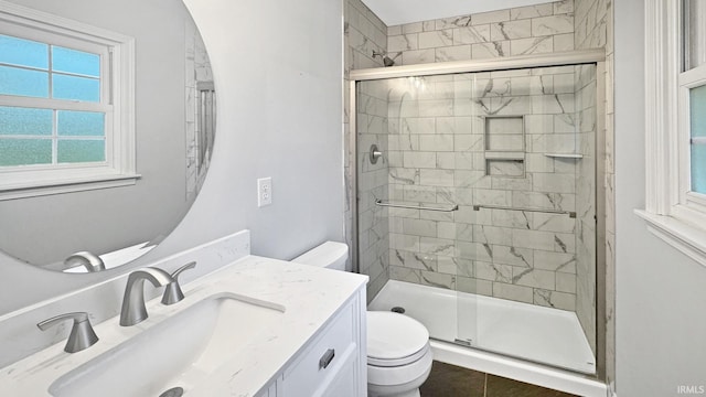 bathroom with tile patterned flooring, toilet, an enclosed shower, and vanity