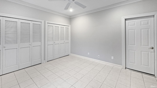 unfurnished bedroom with light tile patterned floors, crown molding, ceiling fan, and multiple closets