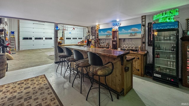 bar with butcher block countertops and black refrigerator