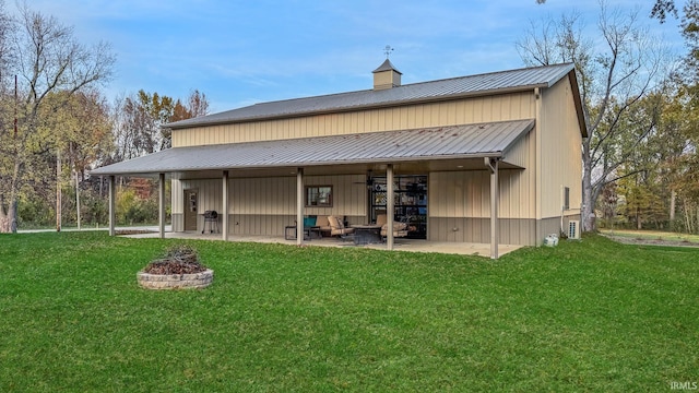 6777 Oak Grove Rd, Newburgh, IN 47630 - back of property with a fire pit, a lawn, metal roof, and a patio