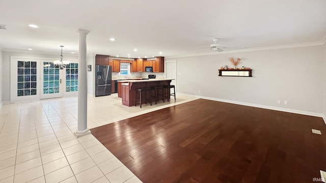 6777 Oak Grove Rd, Newburgh, IN 47630 - kitchen with black appliances, a kitchen bar, ornate columns, open floor plan, and crown molding