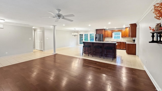 6777 Oak Grove Rd, Newburgh, IN 47630 - kitchen featuring stainless steel fridge with ice dispenser, light wood-style flooring, ceiling fan, decorative columns, and light countertops