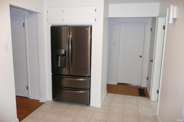 kitchen with stainless steel fridge with ice dispenser, light wood-type flooring, and white cabinetry