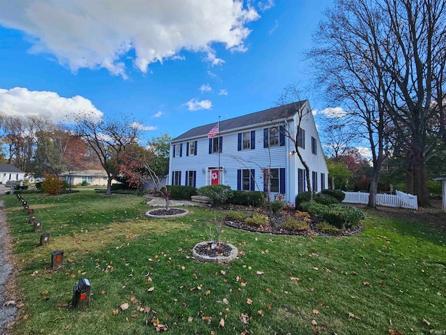 colonial inspired home featuring a front lawn and an outdoor fire pit