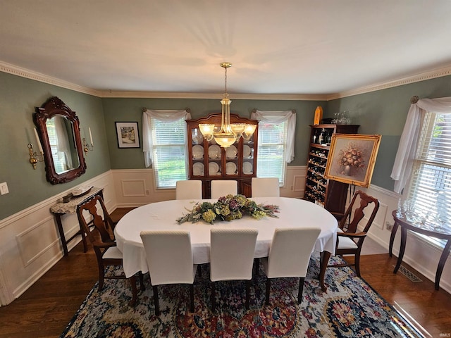 dining room featuring an inviting chandelier, dark hardwood / wood-style floors, and ornamental molding