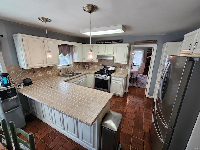 kitchen with white cabinetry, sink, stainless steel appliances, tasteful backsplash, and kitchen peninsula