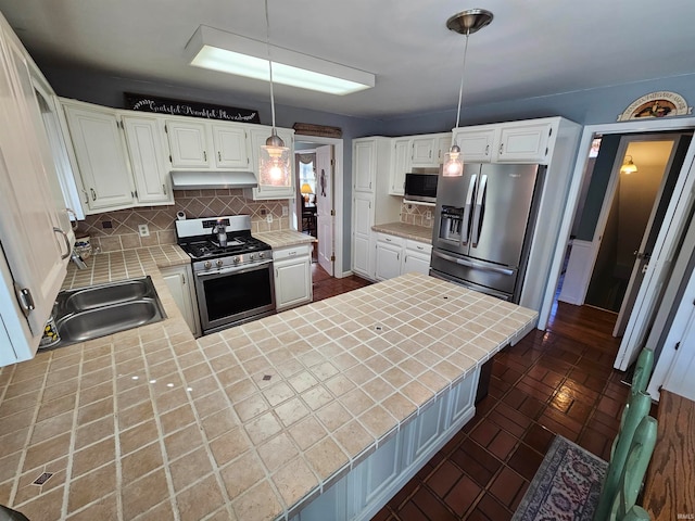 kitchen featuring pendant lighting, white cabinetry, backsplash, and appliances with stainless steel finishes