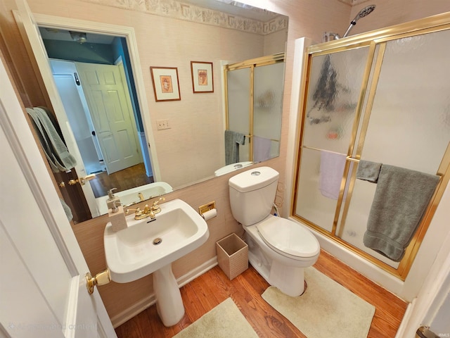 bathroom with toilet, an enclosed shower, and hardwood / wood-style flooring