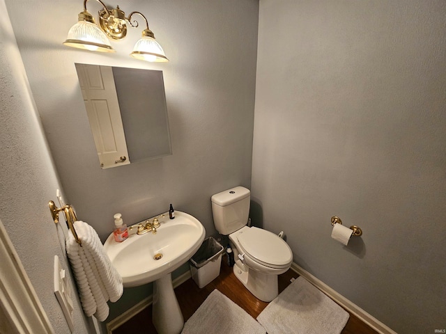 bathroom with hardwood / wood-style flooring and toilet