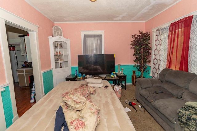 living room featuring hardwood / wood-style floors, ornamental molding, and a textured ceiling