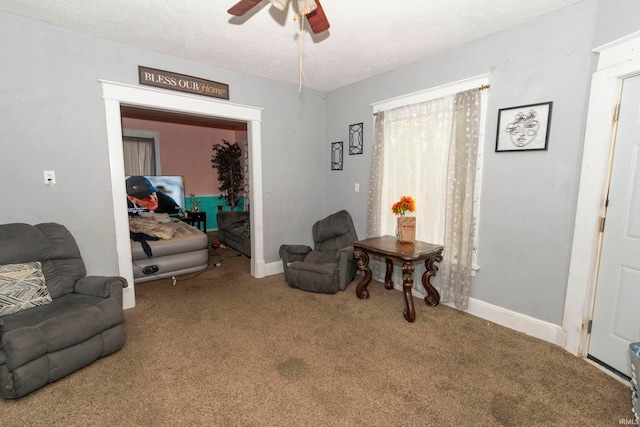 living area featuring carpet flooring and ceiling fan