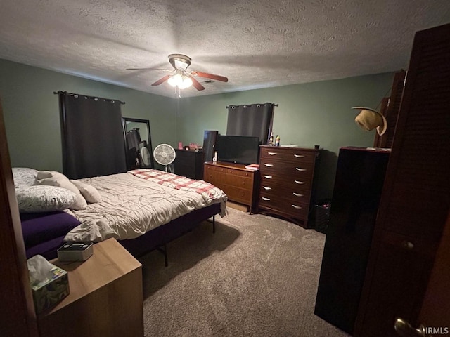 carpeted bedroom featuring ceiling fan and a textured ceiling