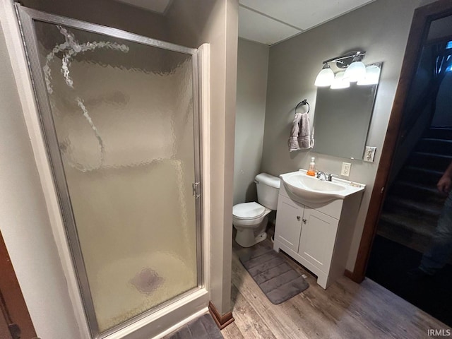 bathroom featuring hardwood / wood-style floors, vanity, an enclosed shower, and toilet