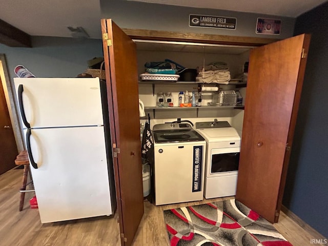 laundry area with separate washer and dryer and light wood-type flooring