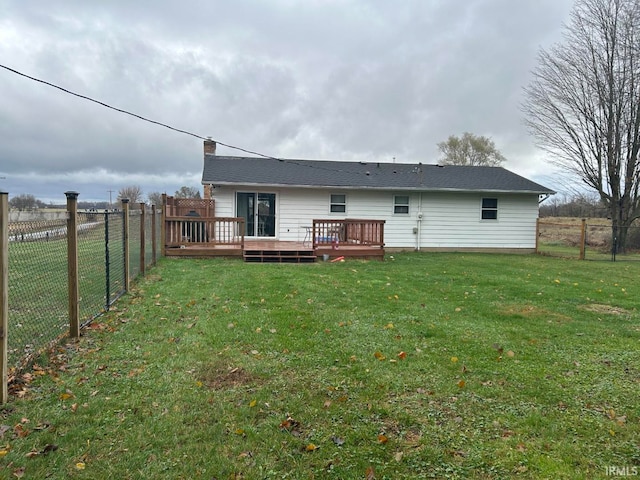 back of property with a yard and a wooden deck