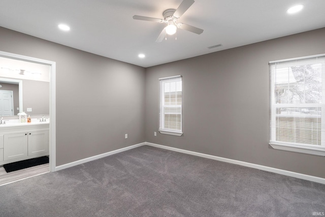 unfurnished bedroom featuring ceiling fan, carpet floors, and ensuite bathroom