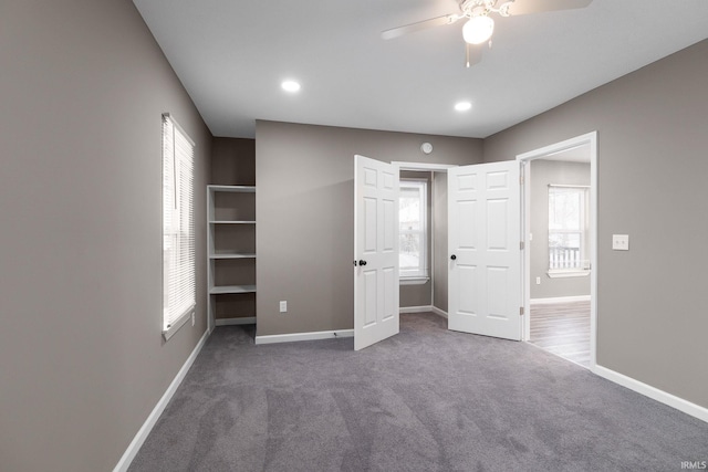 unfurnished bedroom featuring dark colored carpet and ceiling fan