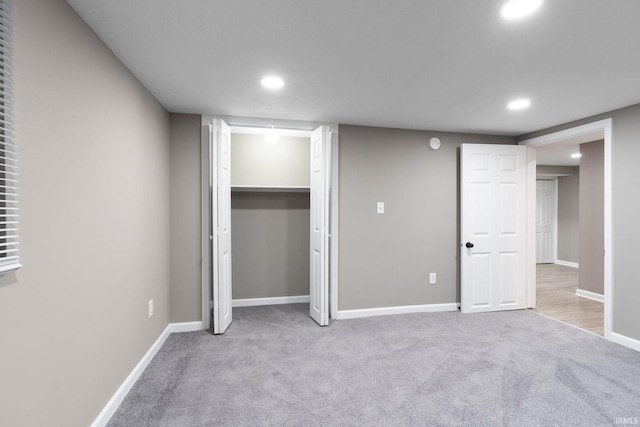 unfurnished bedroom with light colored carpet and a closet