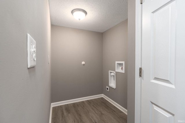 clothes washing area with electric dryer hookup, dark hardwood / wood-style flooring, hookup for a washing machine, and a textured ceiling