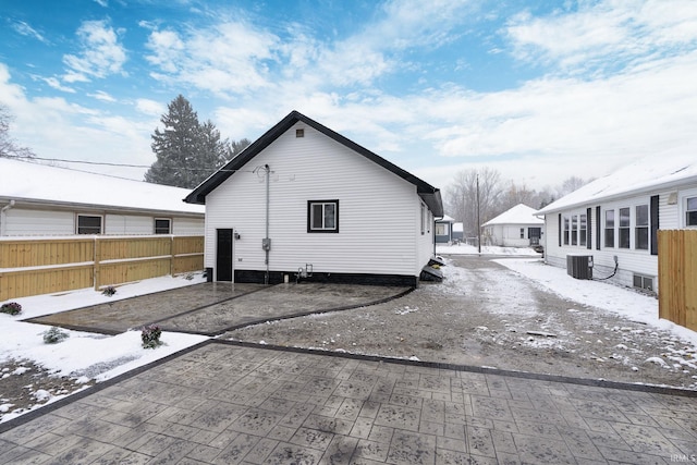 view of snow covered exterior with central AC