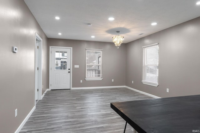 foyer entrance with hardwood / wood-style floors and a notable chandelier