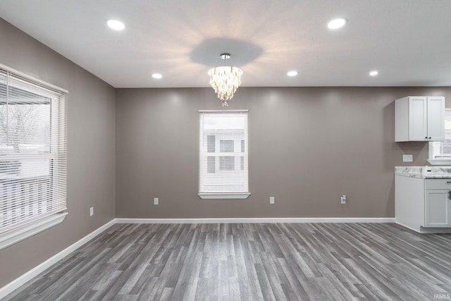 unfurnished dining area featuring hardwood / wood-style floors and an inviting chandelier