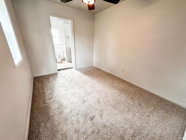 spare room with ceiling fan, plenty of natural light, and carpet