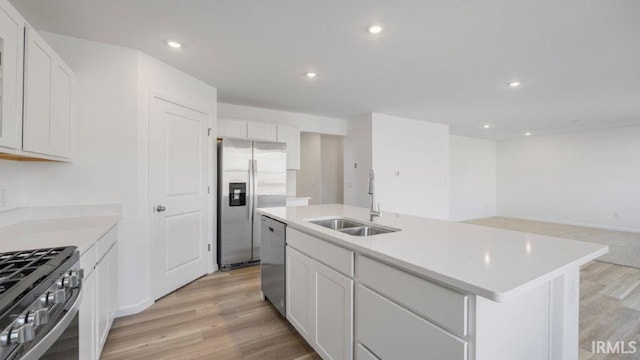 kitchen with white cabinetry, sink, a center island with sink, and appliances with stainless steel finishes