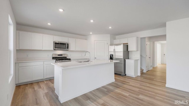 kitchen with white cabinetry, a kitchen island with sink, sink, and stainless steel appliances