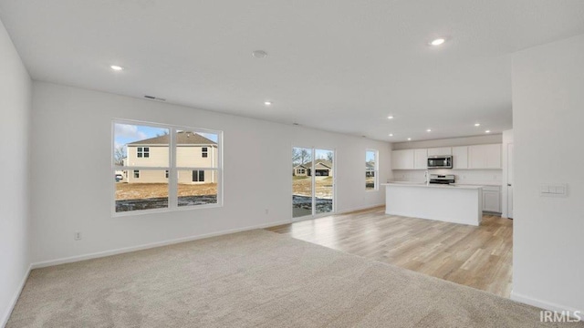 unfurnished living room featuring light carpet