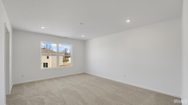 spare room featuring light colored carpet