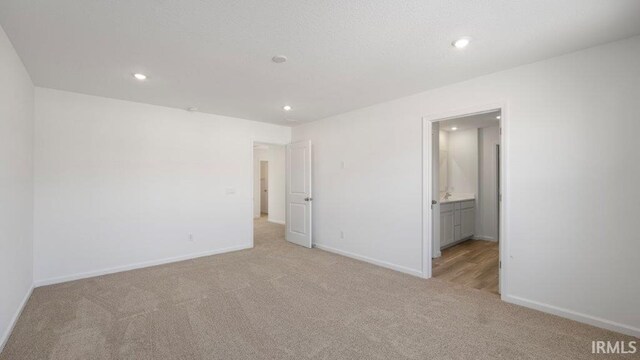 unfurnished room featuring light colored carpet