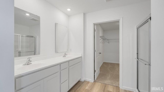 bathroom featuring hardwood / wood-style floors, vanity, and an enclosed shower