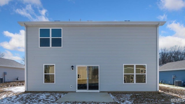 snow covered rear of property with a patio area and central AC unit