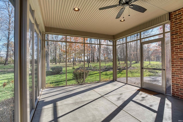 unfurnished sunroom featuring plenty of natural light, wooden ceiling, and ceiling fan