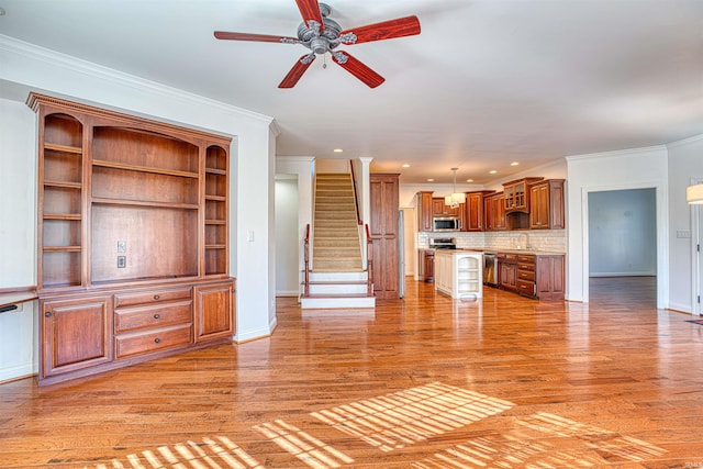 unfurnished living room with hardwood / wood-style flooring, ceiling fan, ornamental molding, and sink