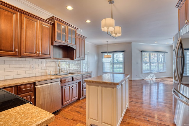 kitchen with sink, a center island, stainless steel appliances, and light wood-type flooring