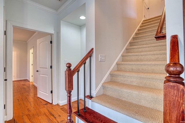 stairs featuring hardwood / wood-style floors and ornamental molding