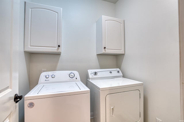 washroom featuring cabinets and independent washer and dryer