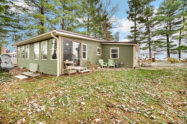 rear view of property with a lawn