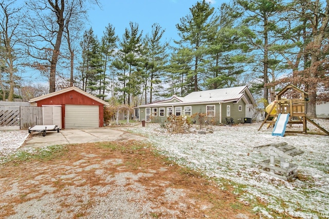 exterior space with an outdoor structure, a garage, and a playground