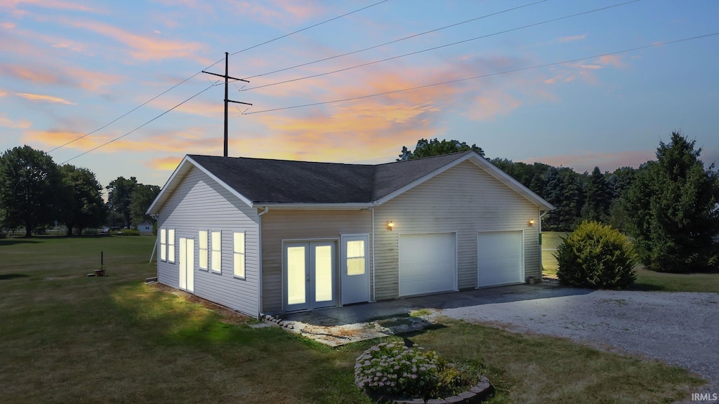 property exterior at dusk with a yard and a garage