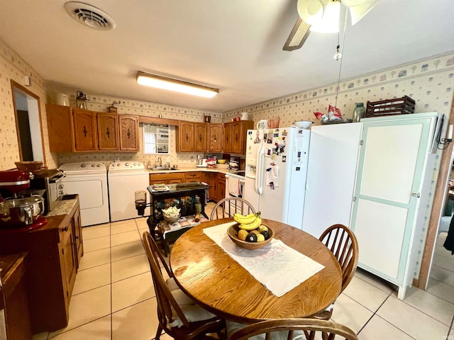 tiled dining area featuring ceiling fan, independent washer and dryer, and sink