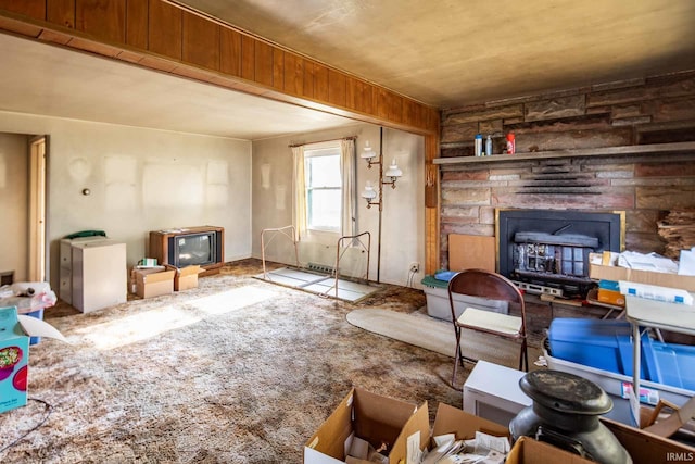 living room featuring a fireplace and wood walls