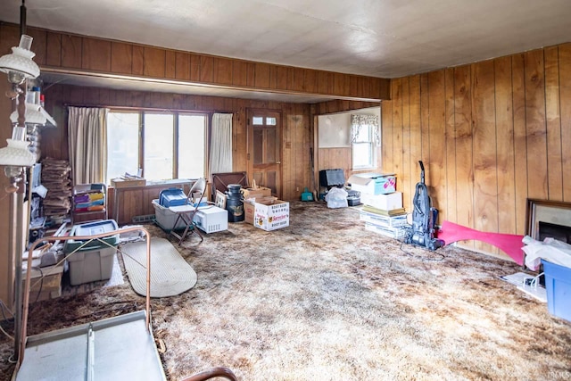 living room with a fireplace, a healthy amount of sunlight, and wood walls