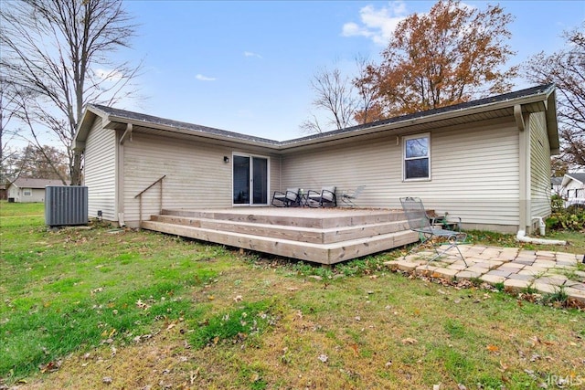 rear view of house featuring a deck, cooling unit, and a lawn